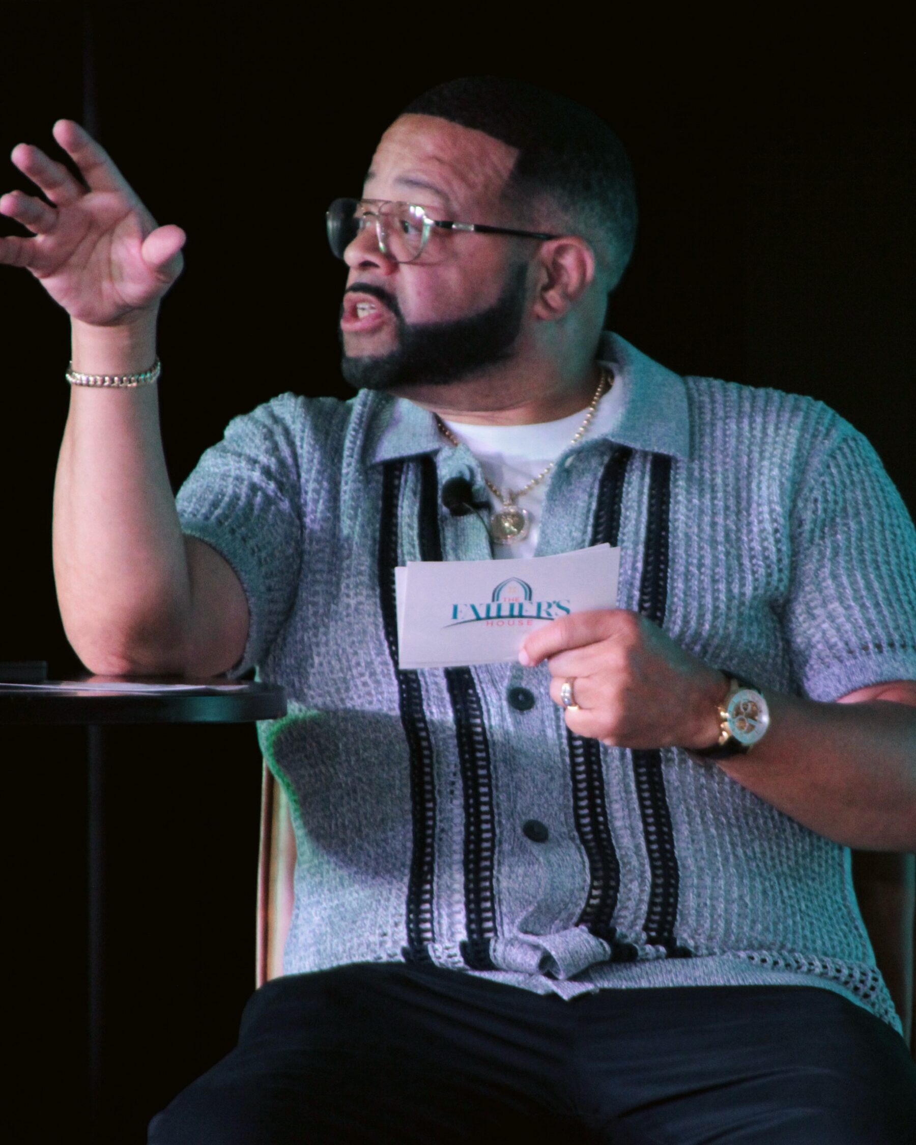 Pastor Kori Stith preaching, one hand raised